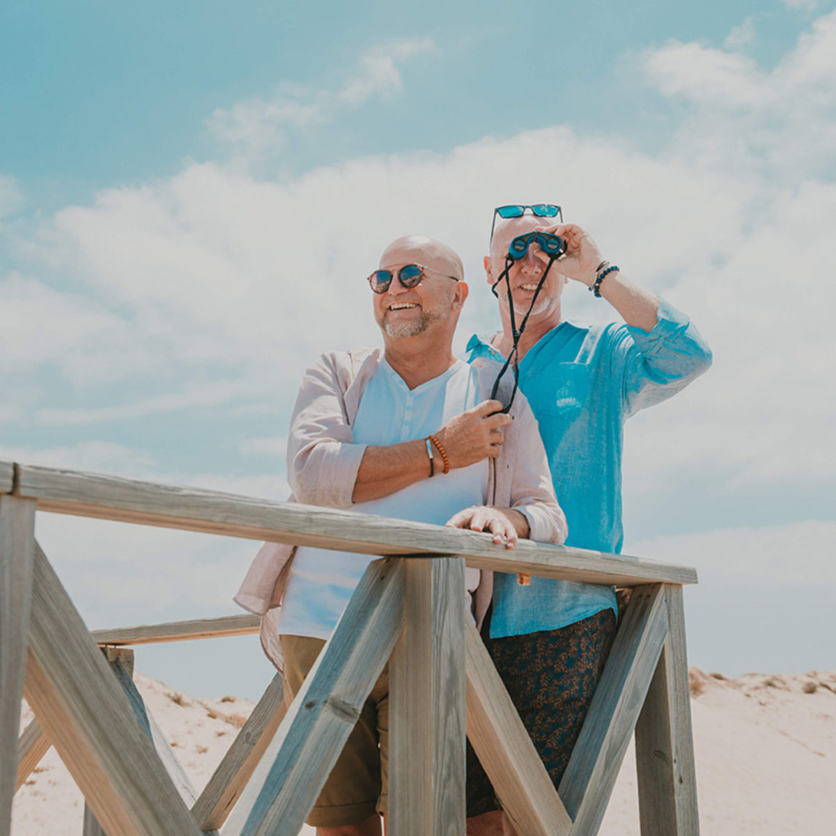 Senior gay couple with binoculars at Quinta do Lago, Algarve, Portugal